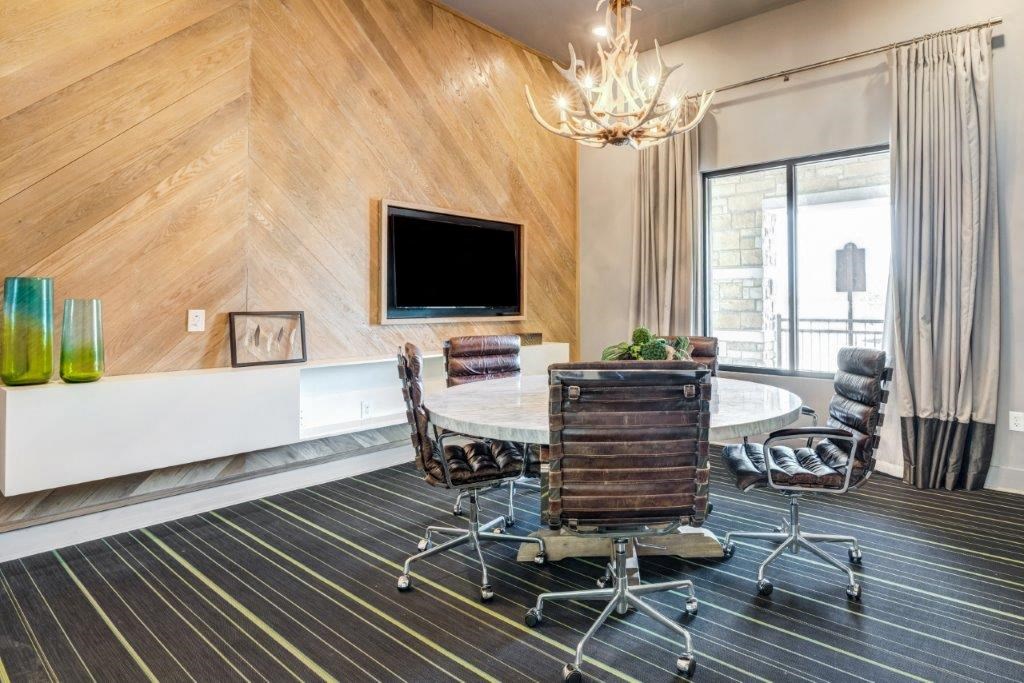 a conference room with a table and chairs and a tv
