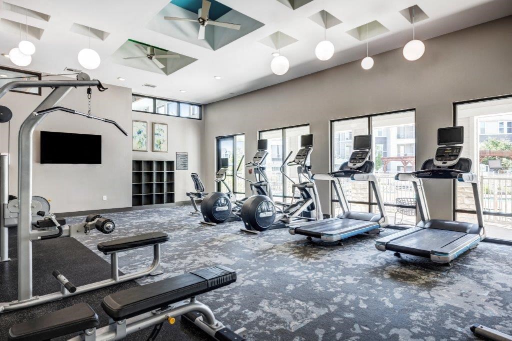 a gym with weights and a tv on the wall