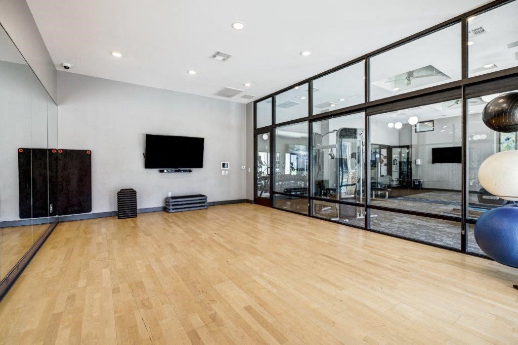 the living room has a hardwood floor and large windows