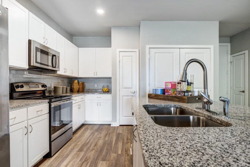 a kitchen with granite counter tops and white cabinets