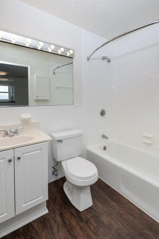 a white bathroom with a toilet and a tub and a sink