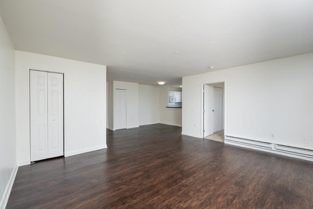 an empty living room with white walls and wood floors