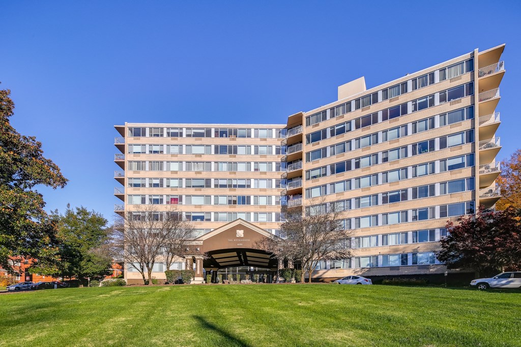 a large apartment building on a green lawn