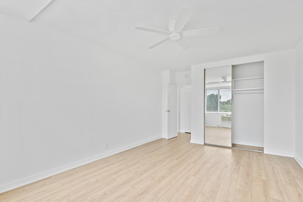 an empty room with white walls and a ceiling fan