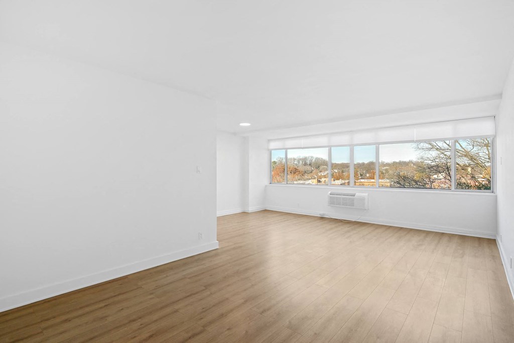 an empty living room with white walls and a window