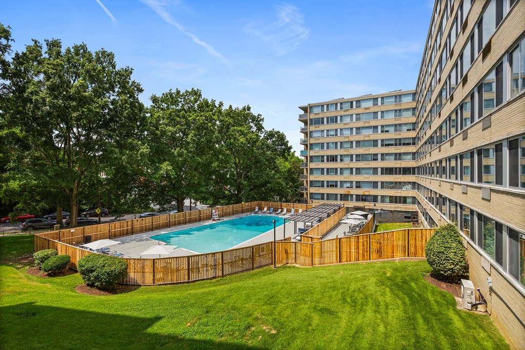 a backyard with a pool and a building with trees