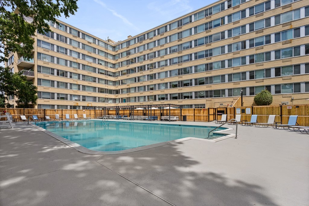 a swimming pool in front of a hotel with a building