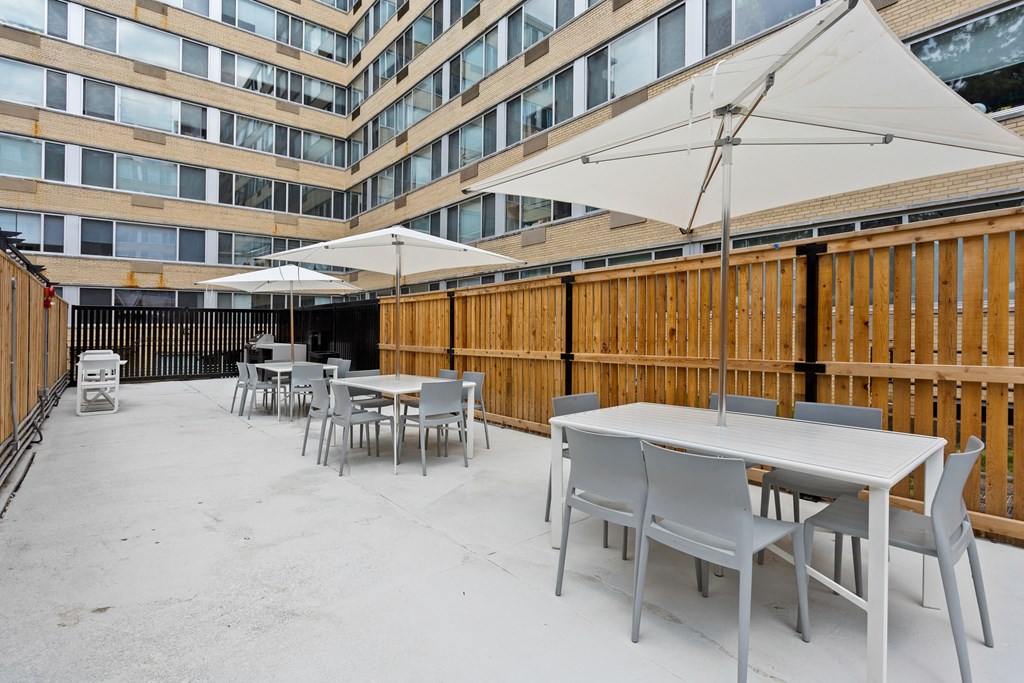 a patio with tables and chairs and umbrellas