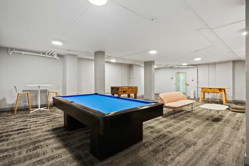 a game room with a pool table and chairs