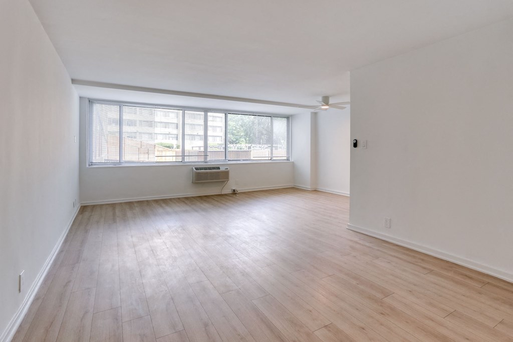 an empty living room with wood floors and a window