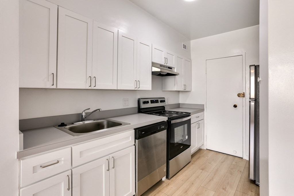 a kitchen with white cabinetry and stainless steel appliances