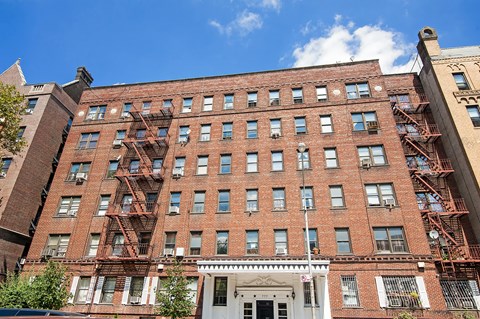 A red brick building with a white door and windows.