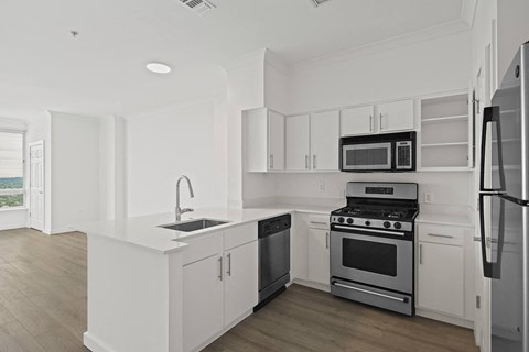 a kitchen with white cabinets and stainless steel appliances