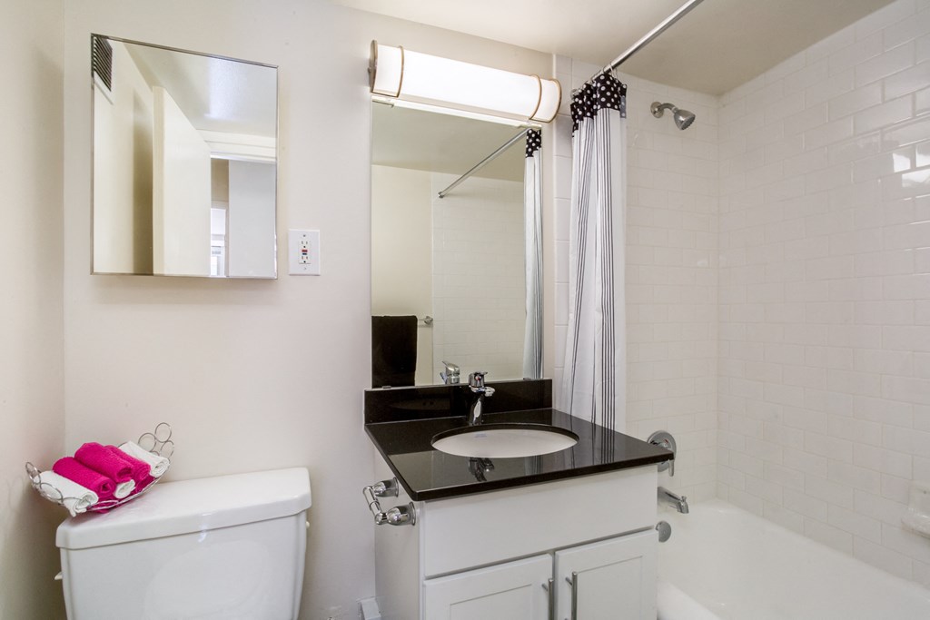 A bathroom with a white toilet, sink, and bathtub.