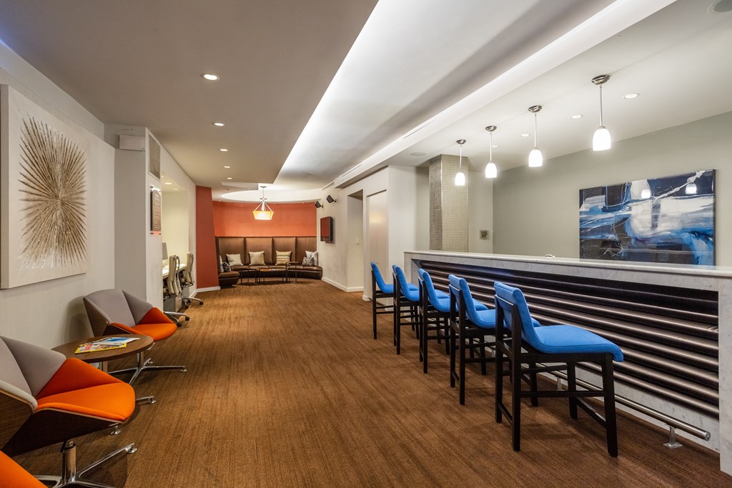 A long hallway with blue chairs on the right side.