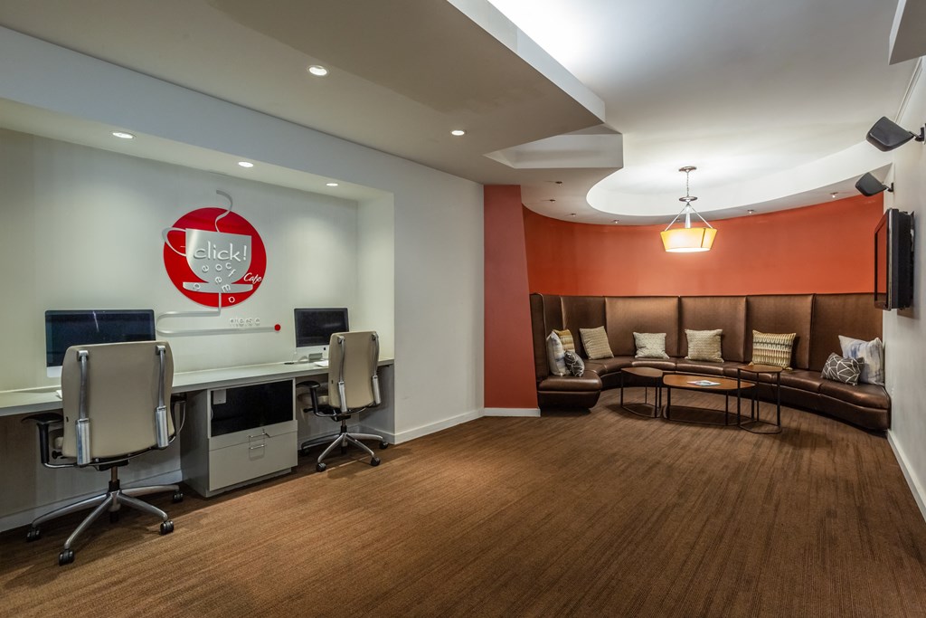 A conference room with a logo on the wall and a couch.