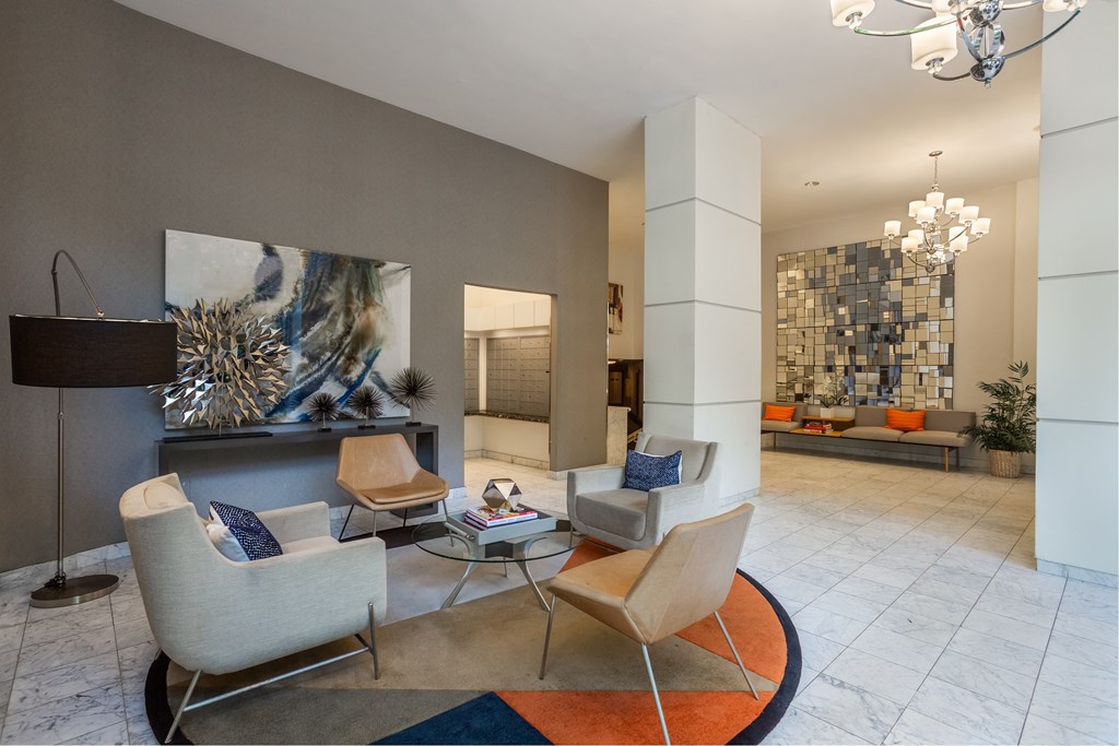 A living room with a grey couch and a white chair.
