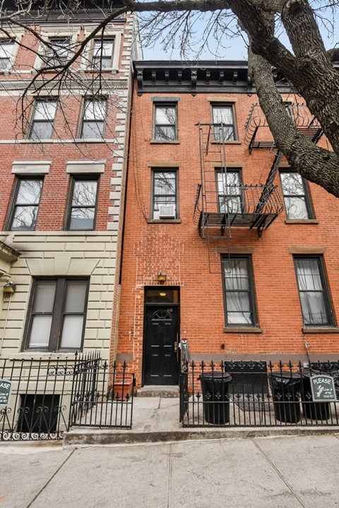 A red brick building with a black door and windows.