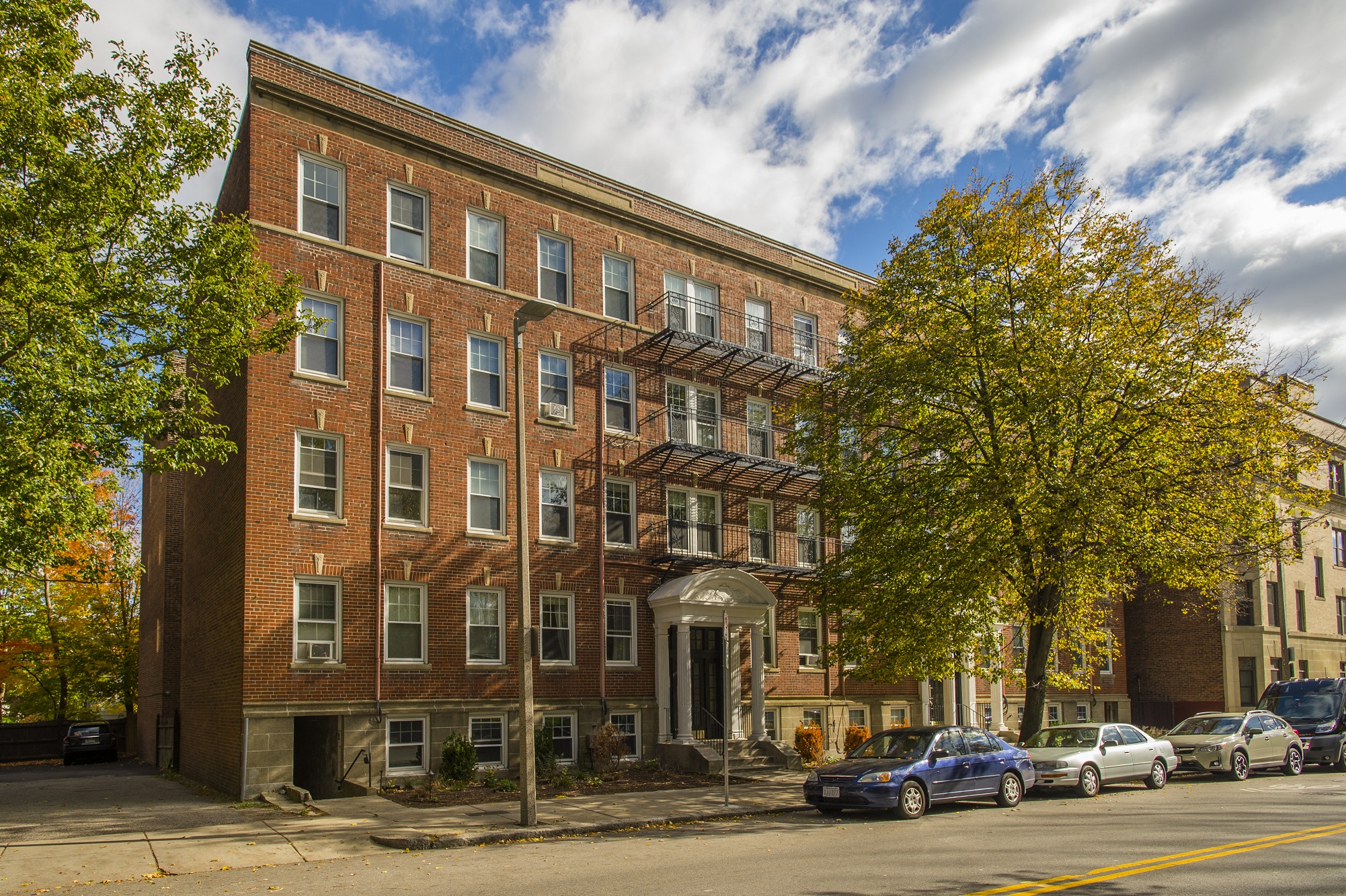 A red brick building with a tree in front of it.
