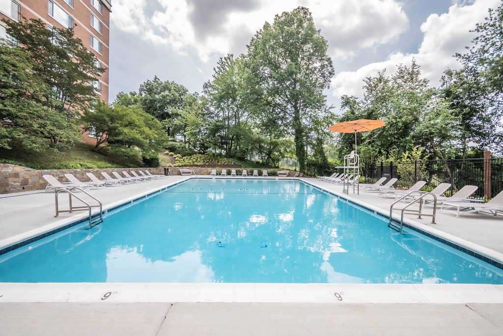 a swimming pool with chairs and an umbrella at a hotel