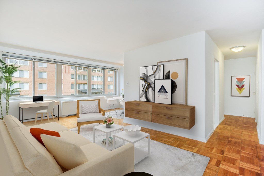 A living room with a couch, a coffee table, and a painting on the wall.