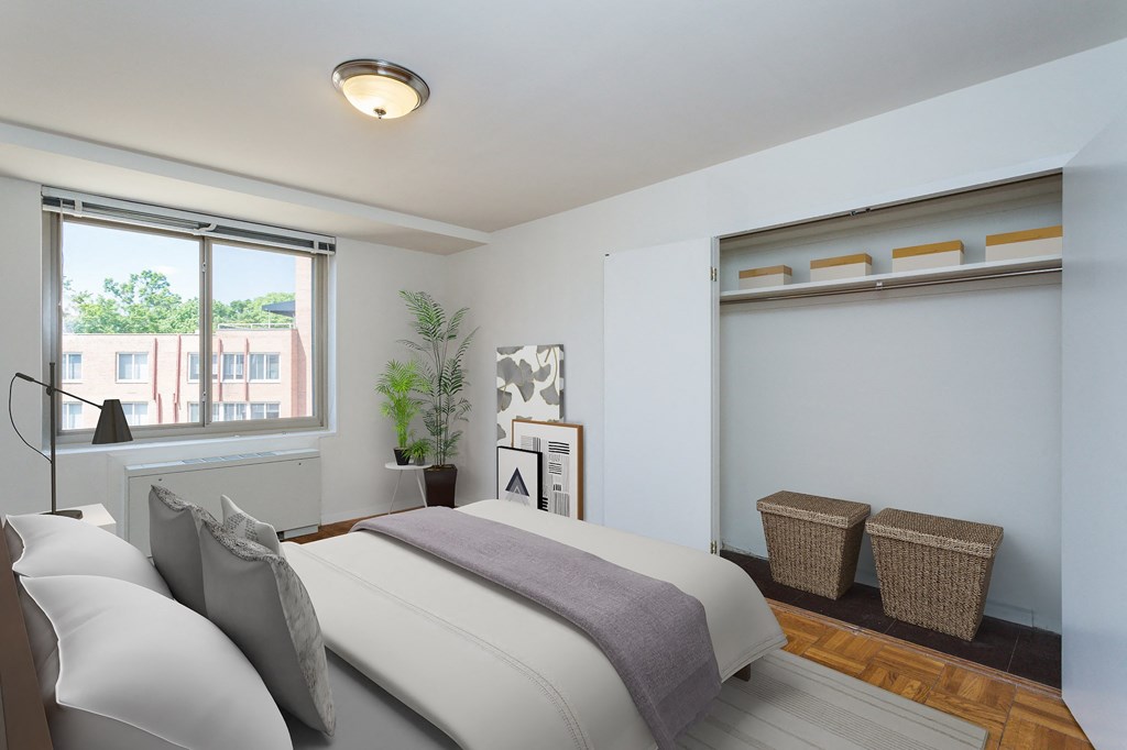 A bedroom with a large bed and a window overlooking a building.