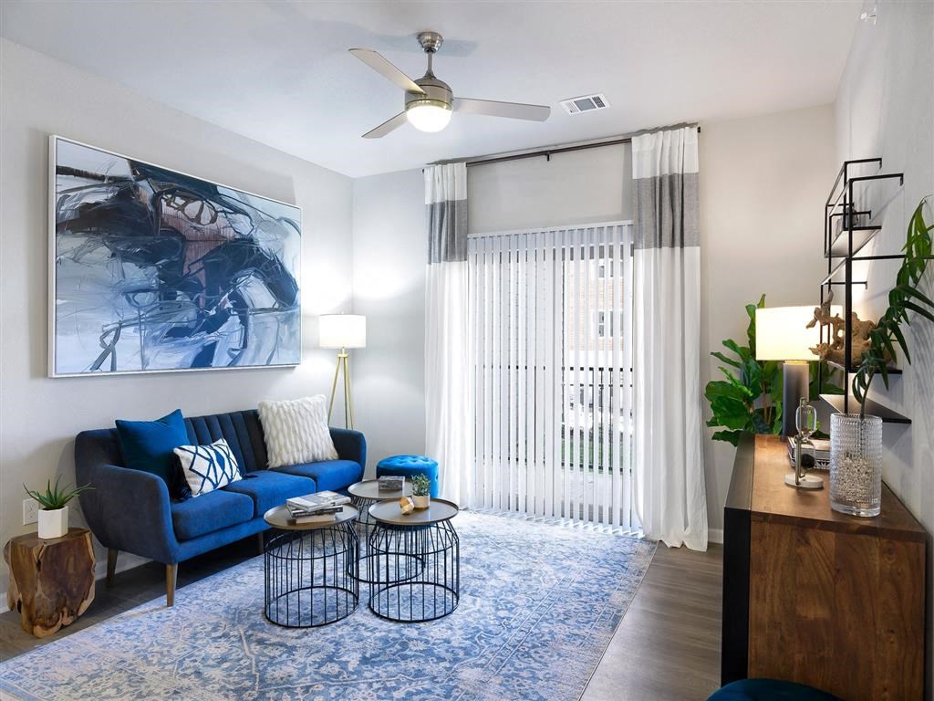 a living room with a blue couch and a ceiling fan