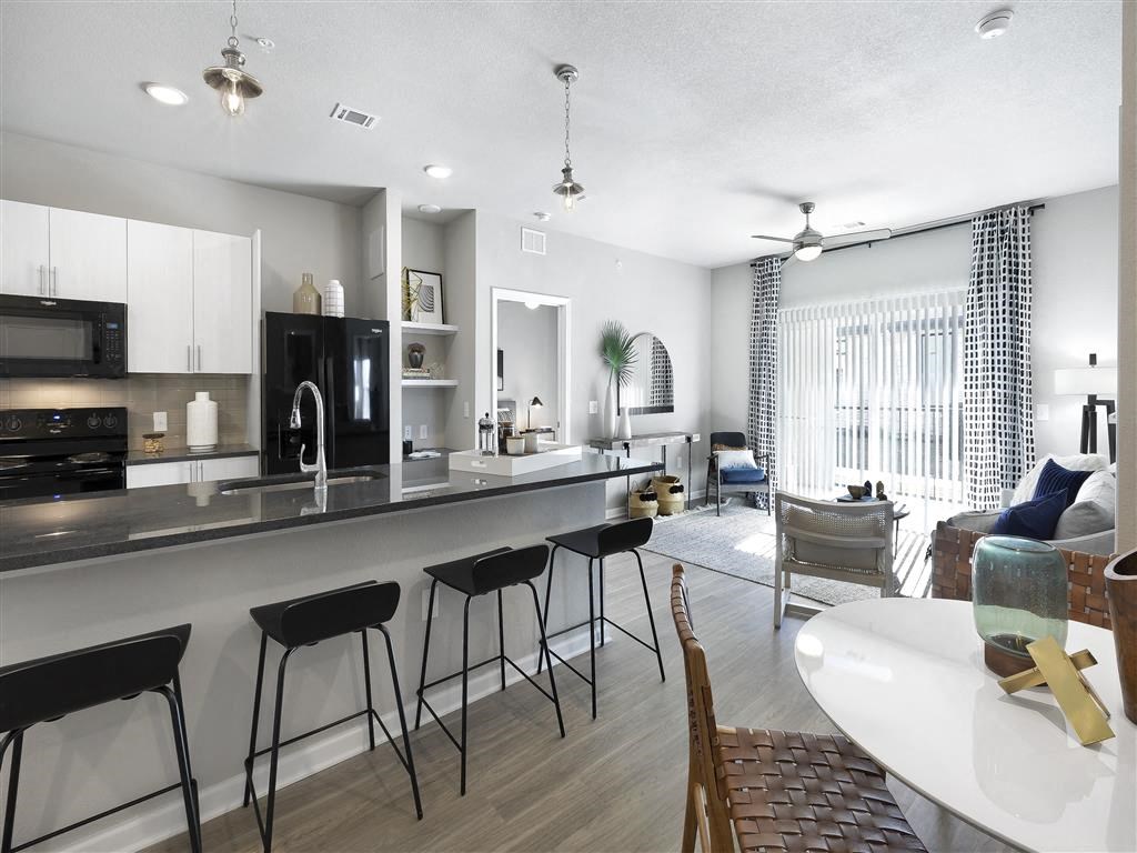 an open kitchen and living room with a bar and a table