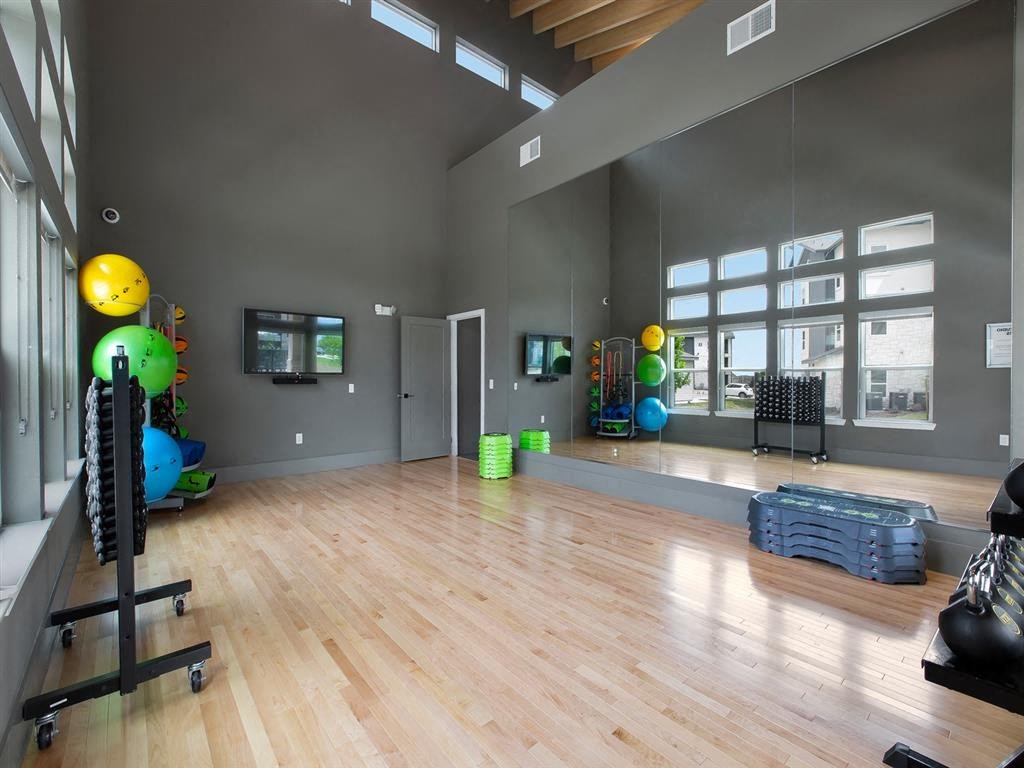 a gym with a hardwood floor and a large window