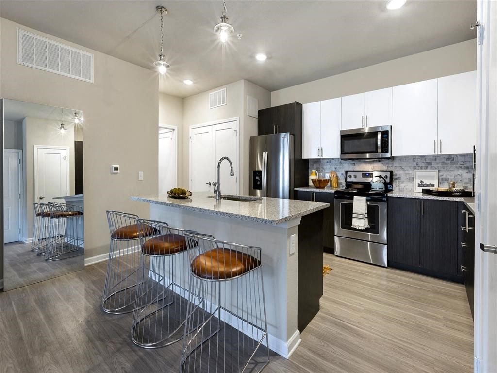 a kitchen with a counter and a bar with chairs