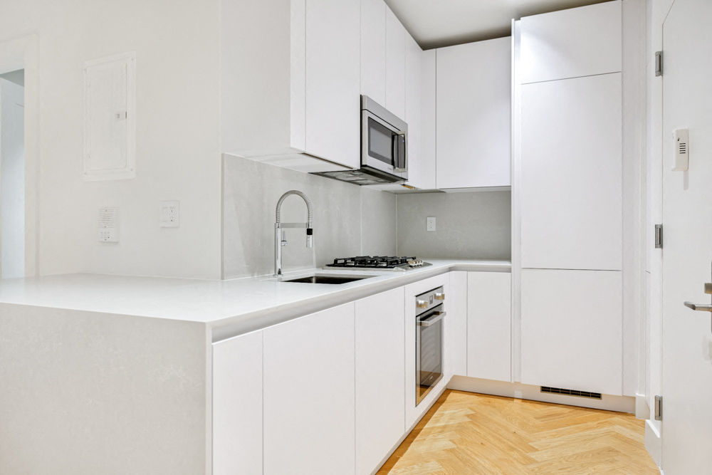 A white kitchen with a microwave above the stove.
