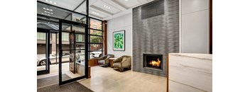 A modern living room with a fireplace and a painting on the wall.