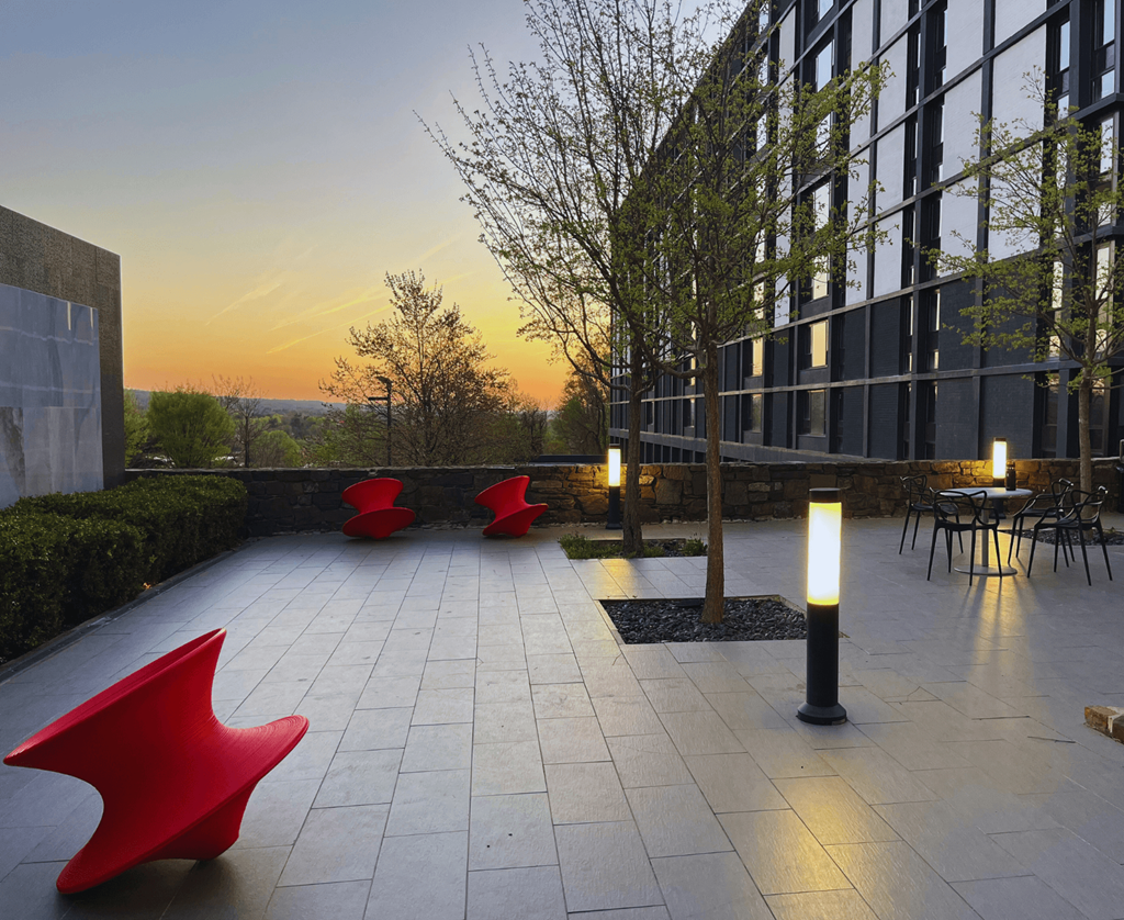 a terrace with red chairs and a building in the background