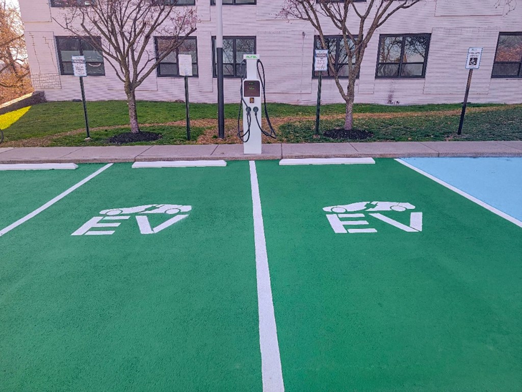 a green basketball court in front of a white building