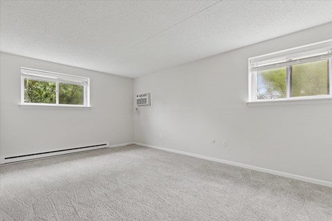 A white room with a window and a carpet on the floor.