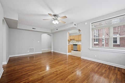 A room with wooden floors and a ceiling fan.