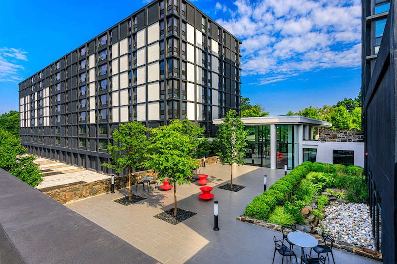 A modern building with a green outdoor seating area.