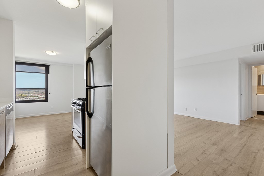 A modern kitchen with stainless steel appliances and wooden flooring.