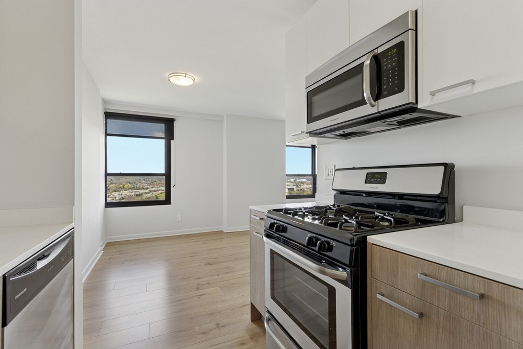 A modern kitchen with stainless steel stove, oven, and microwave.