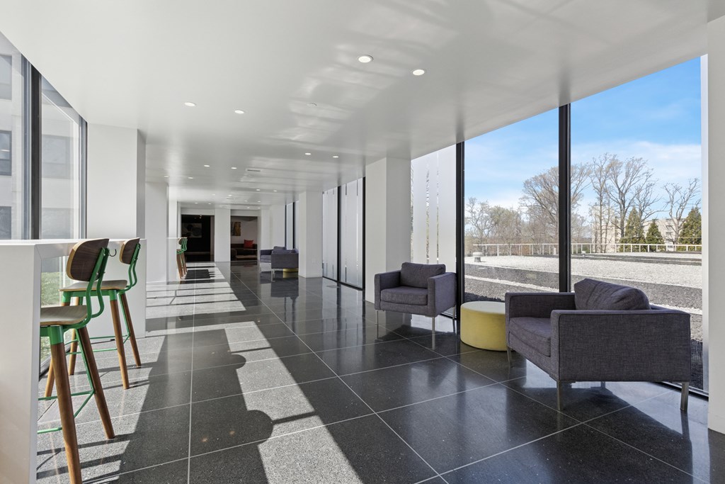 A long hallway with chairs and a table on the right side.