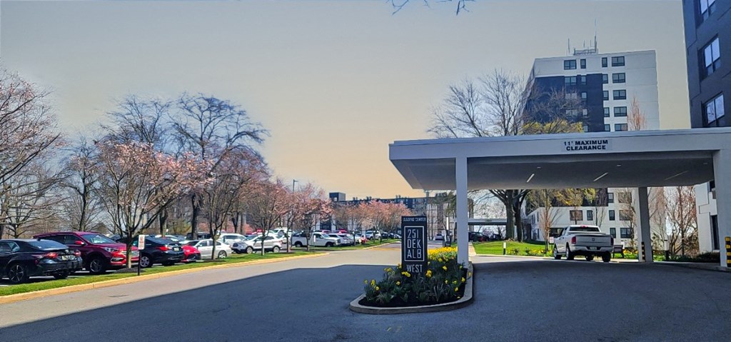 a gas station with a parking lot in the foreground and a building in the background
