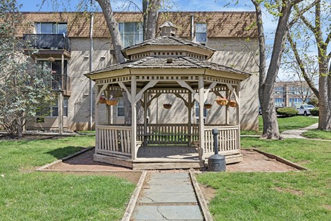 A gazebo is in the middle of a grassy area.