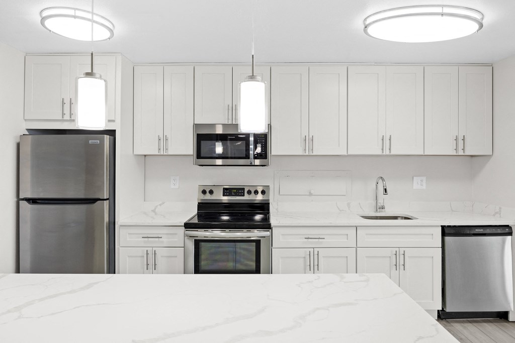 a kitchen with white cabinets and stainless steel appliances