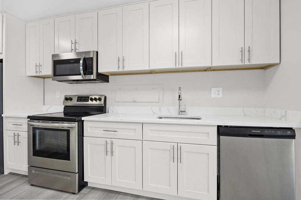 a kitchen with white cabinets and stainless steel appliances