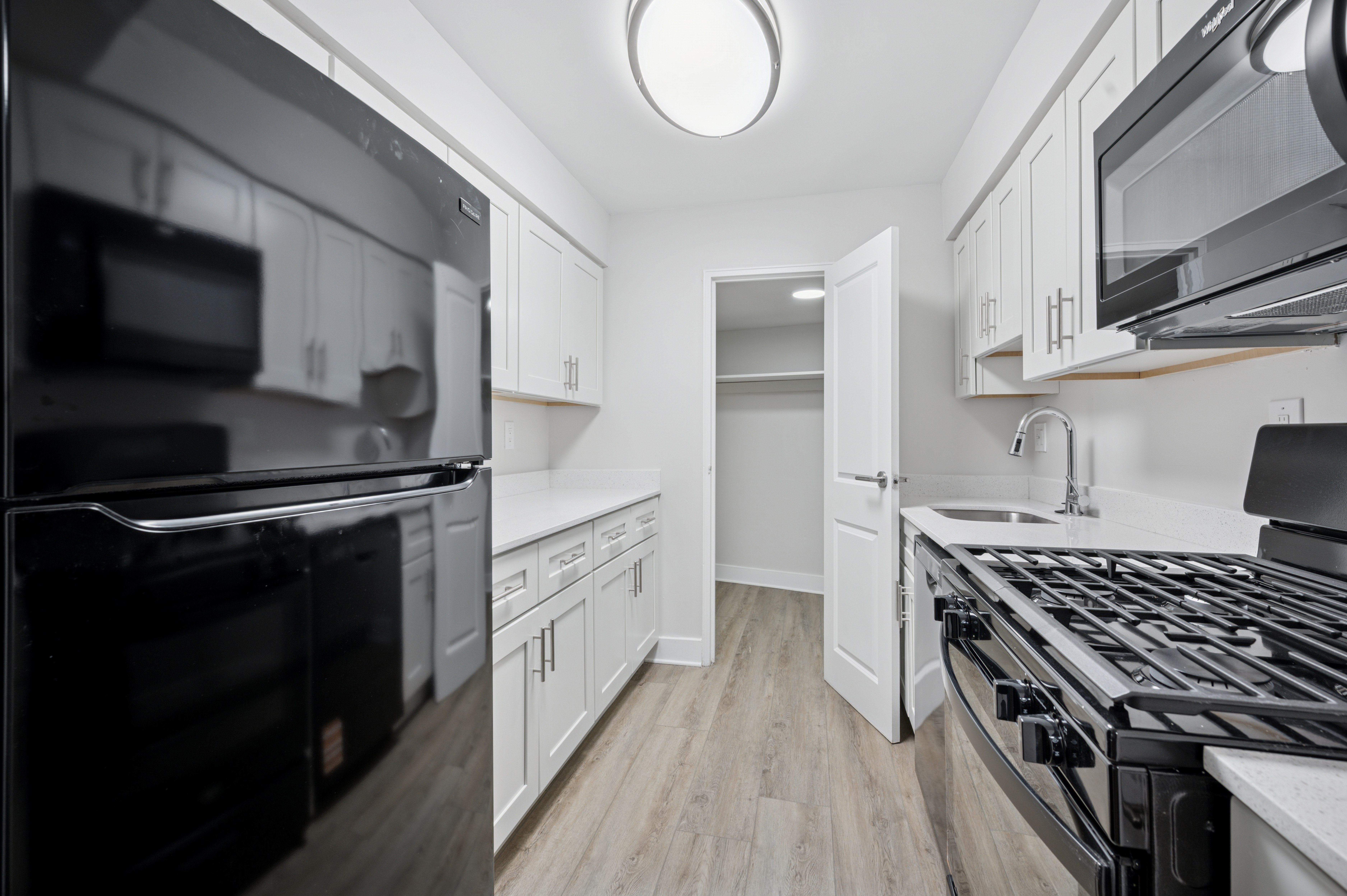 A modern kitchen with black appliances and white cabinets.