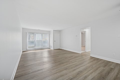 A room with wooden flooring and white walls.