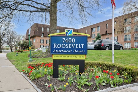 A sign for 7400 Roosevelt Apartment Homes is displayed in front of a building.