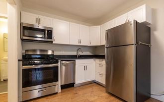Studio style White Kitchen with updated stainless steel appliances