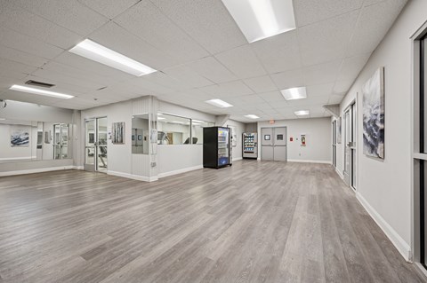 A spacious room with wooden floors and white walls.