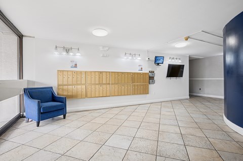 A blue chair is in a white room with a wooden bench.